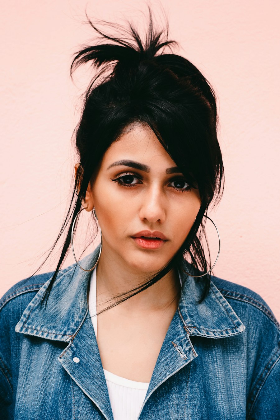 Studio headshot on a blue ground, natural expression.